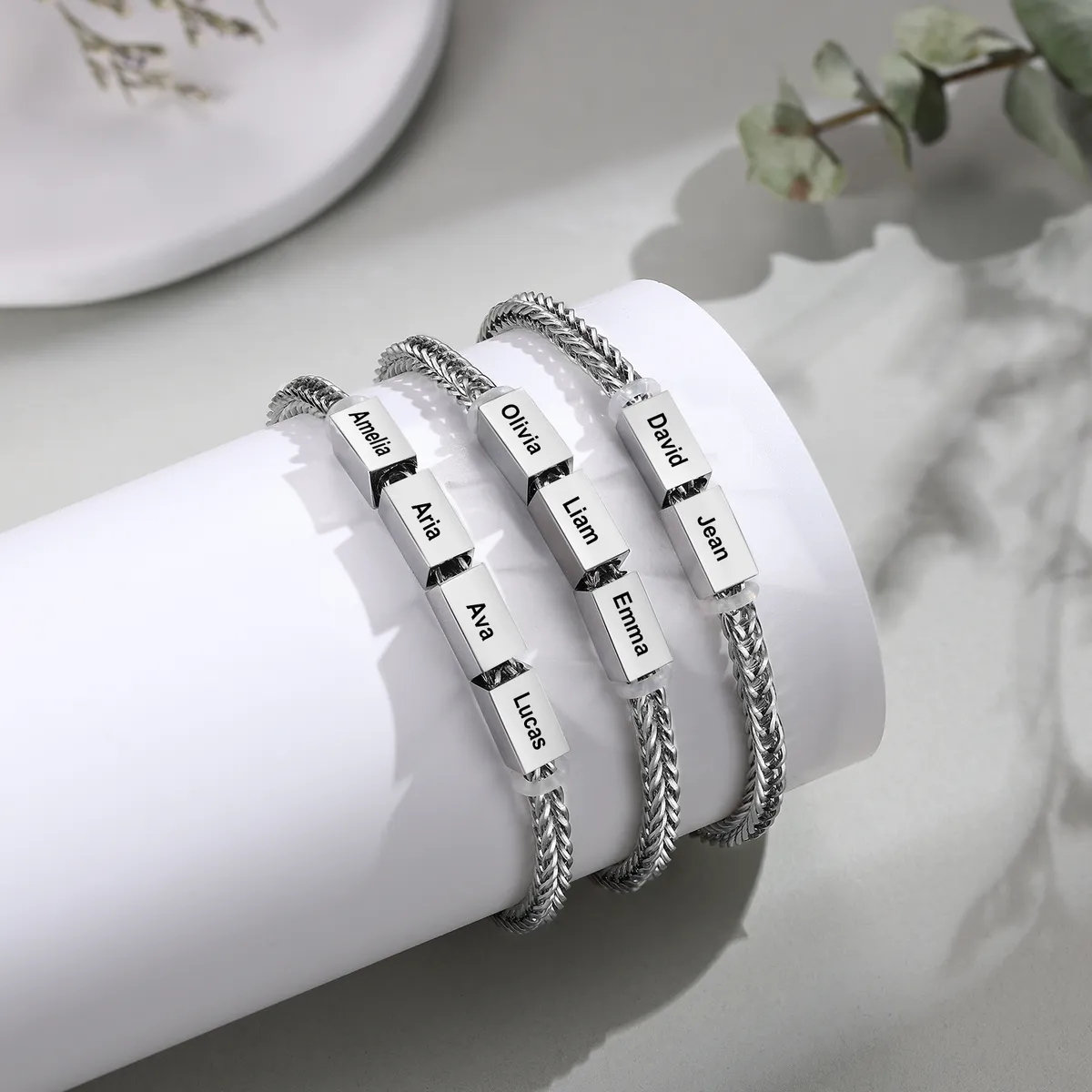 Engraved family bracelets with names, laid out in sterling silver