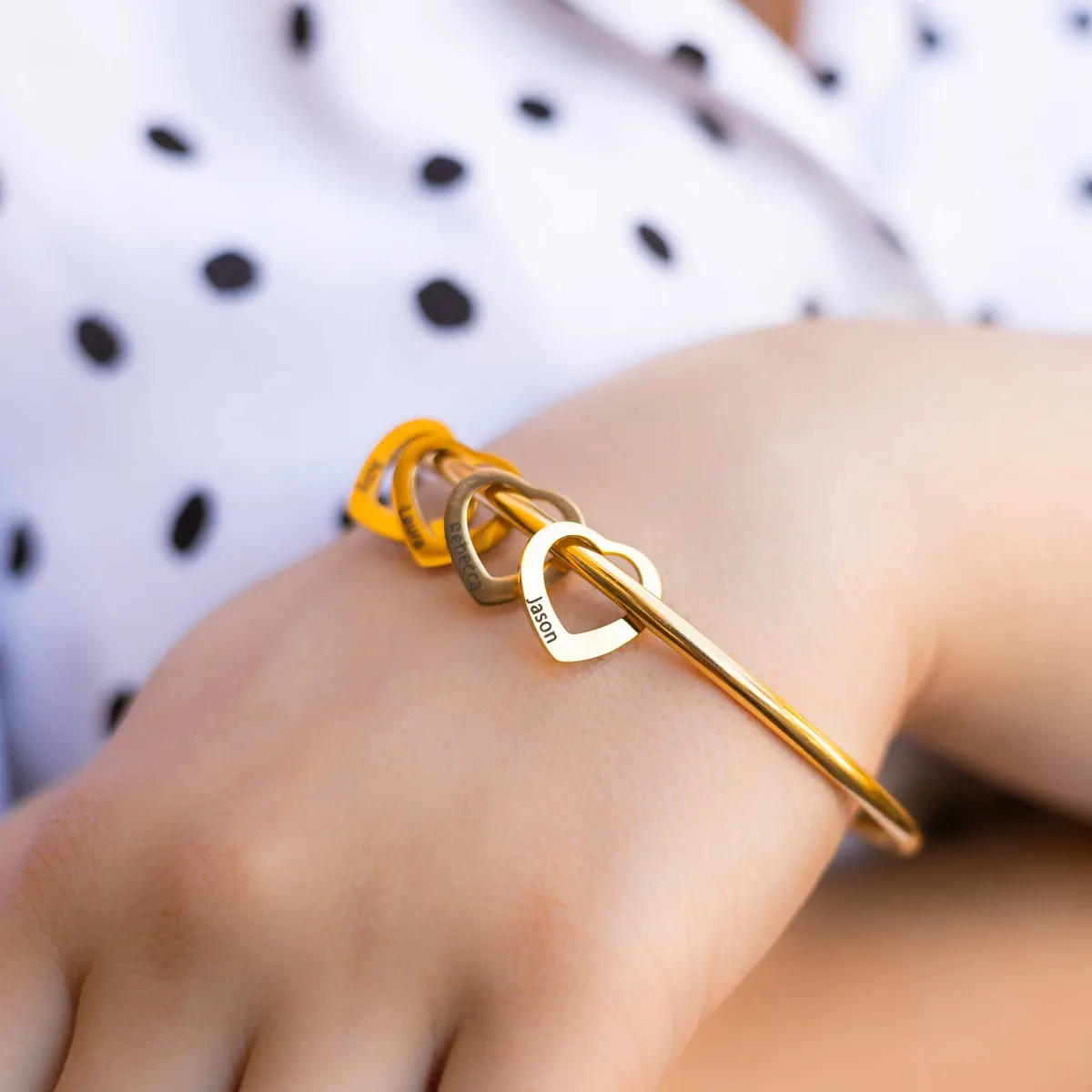 Gold personalized heart bangle worn on a wrist
